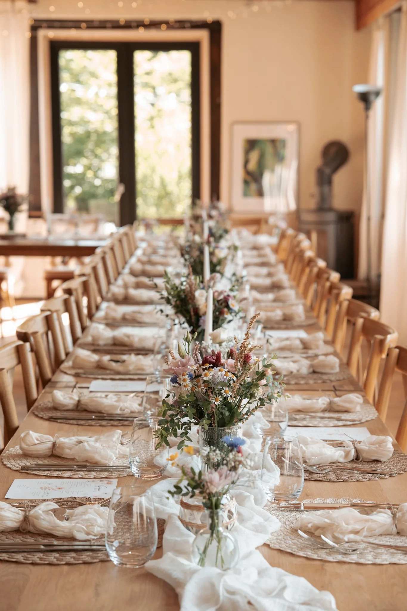 Lange festlich gedeckte Tafel mit Holzstühlen